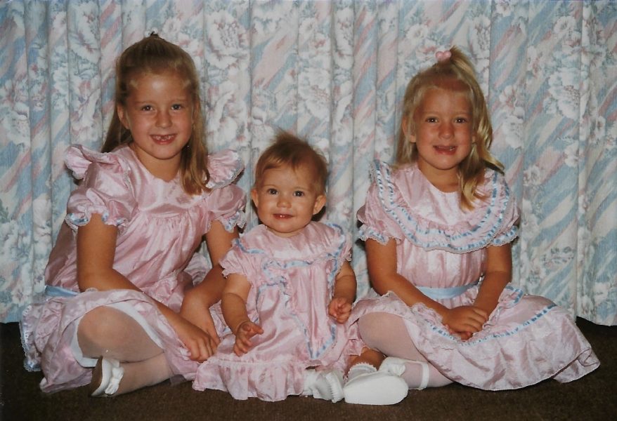 Three girls in matching pink and blue dresses
